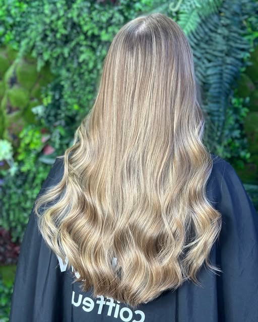 Warme blonde Balayage mit weichen Wellen