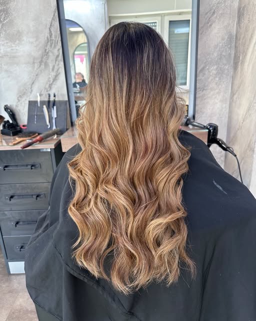 Karamell-Balayage mit Locken im Salon